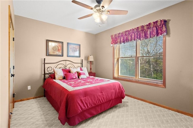 carpeted bedroom with ceiling fan and baseboards