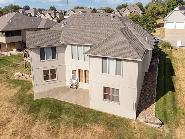 back of property featuring a patio area, a residential view, a lawn, and roof with shingles