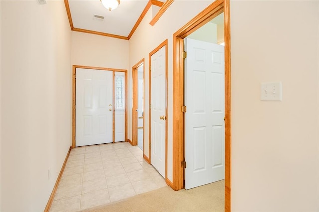 hall featuring ornamental molding and light tile patterned floors