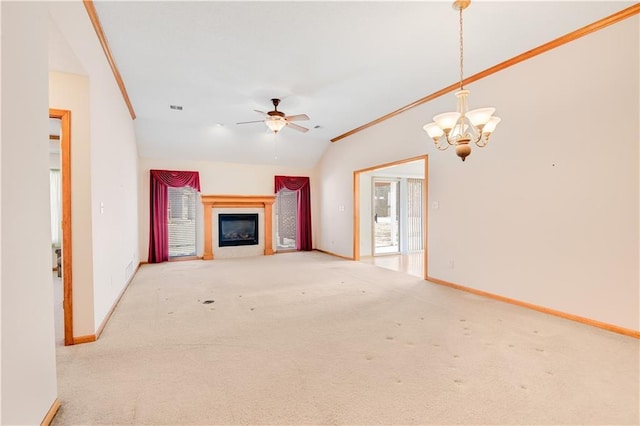 unfurnished living room featuring ceiling fan with notable chandelier, vaulted ceiling, and light colored carpet