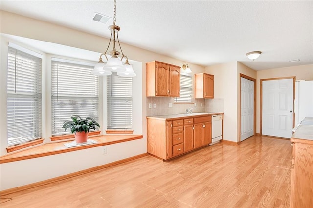 kitchen featuring sink, white appliances, backsplash, decorative light fixtures, and light wood-type flooring