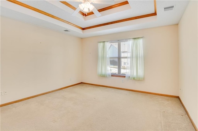 carpeted spare room featuring ceiling fan and a raised ceiling