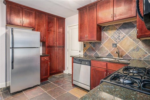 1102 W 46th St Unit 3, Kansas City, MO 64111 - kitchen with stainless steel appliances, dark brown cabinets, tasteful backsplash, stone tile flooring, and dark stone countertops