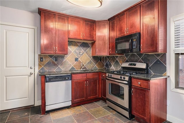 1102 W 46th St Unit 3, Kansas City, MO 64111 - kitchen featuring appliances with stainless steel finishes, reddish brown cabinets, decorative backsplash, and dark stone finish floors