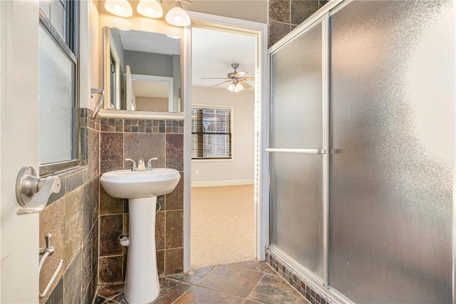 1102 W 46th St Unit 3, Kansas City, MO 64111 - bathroom with ceiling fan, a shower stall, stone finish floors, and tile walls