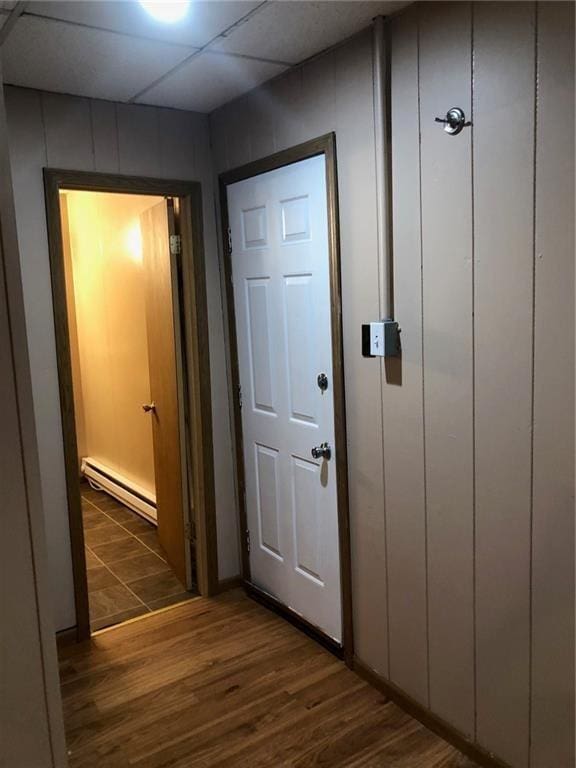 entryway featuring a drop ceiling, dark wood-type flooring, and a baseboard radiator