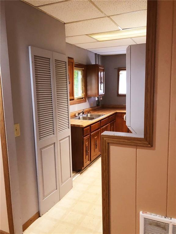 kitchen with plenty of natural light, kitchen peninsula, sink, and a drop ceiling