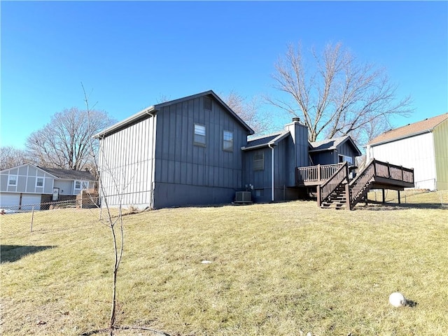 rear view of property with a wooden deck, a yard, and central air condition unit