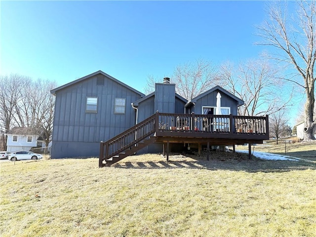 rear view of property with a wooden deck and a lawn