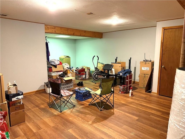 basement with hardwood / wood-style flooring and a textured ceiling