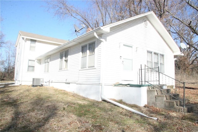 view of property exterior featuring a lawn and central air condition unit