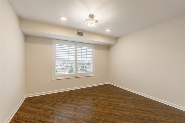 unfurnished room with dark wood-type flooring