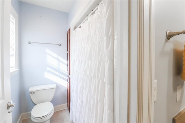 bathroom featuring a wealth of natural light, tile patterned floors, and toilet