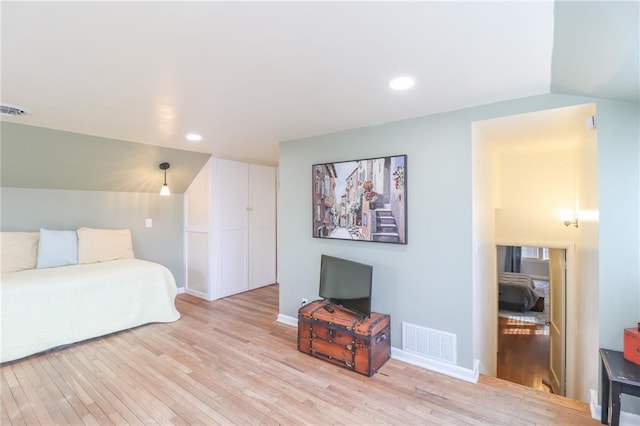 bedroom featuring vaulted ceiling and light hardwood / wood-style flooring