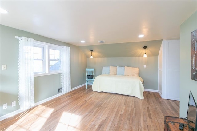 bedroom with lofted ceiling and light hardwood / wood-style flooring