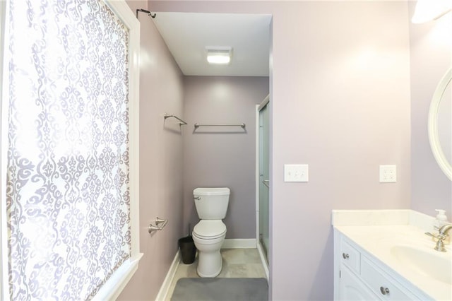 bathroom with vanity, tile patterned flooring, a shower with shower door, and toilet