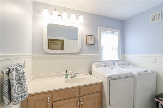 clothes washing area featuring washer and clothes dryer and sink