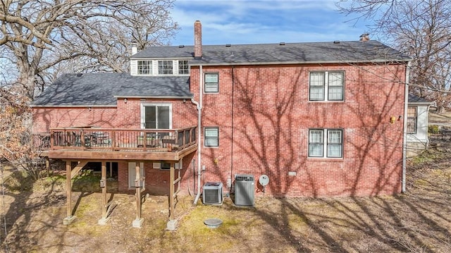 rear view of house with a wooden deck, a yard, and central air condition unit