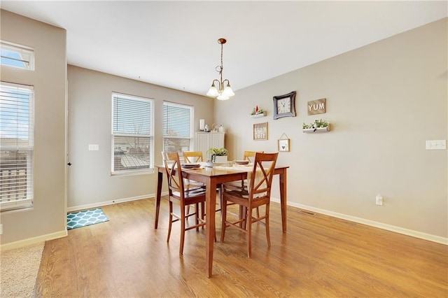 dining area with a chandelier and light hardwood / wood-style flooring