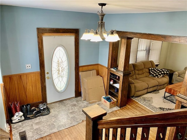 living room featuring a chandelier and wood walls