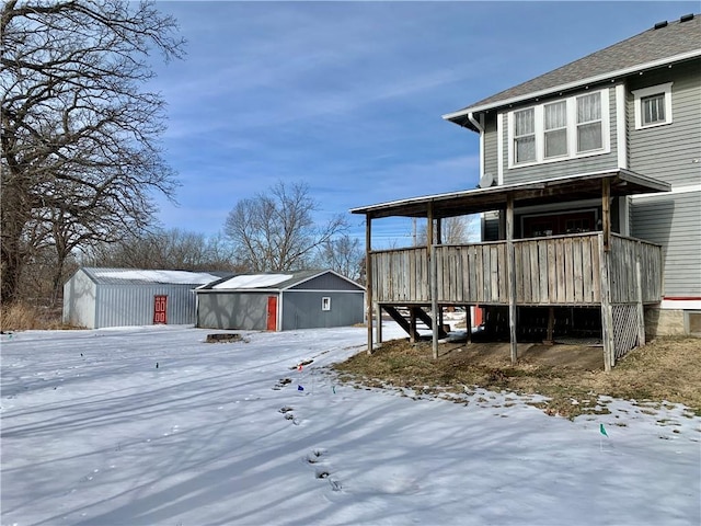 snowy yard with an outdoor structure and covered porch