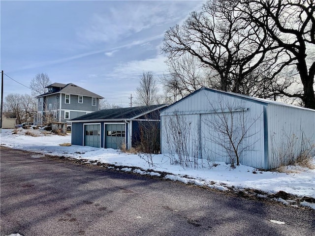 snow covered structure featuring a garage