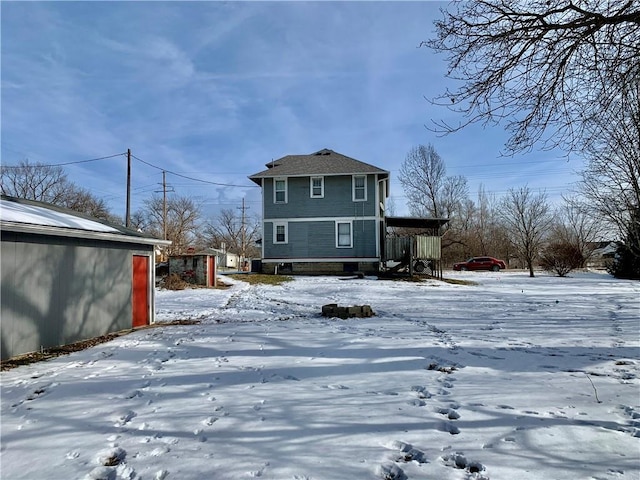 view of snow covered back of property