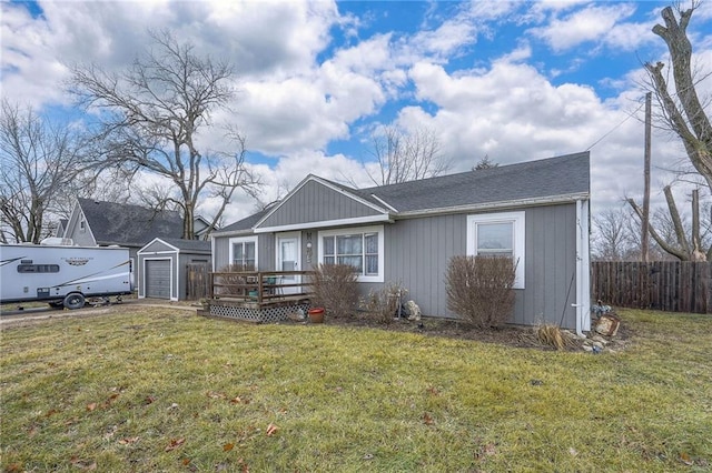 view of front of property with an outbuilding, a garage, a deck, and a front yard