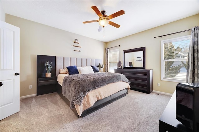 bedroom with light carpet, ceiling fan, and baseboards