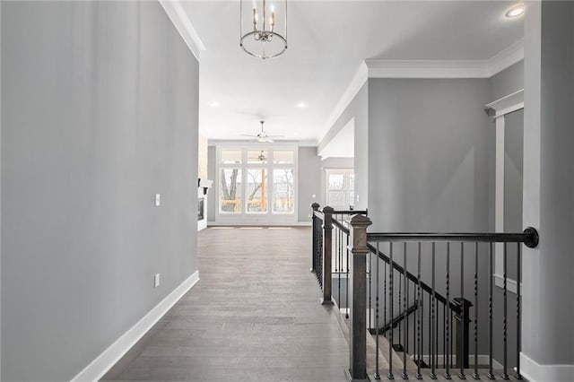 hallway with crown molding, wood-type flooring, and a notable chandelier