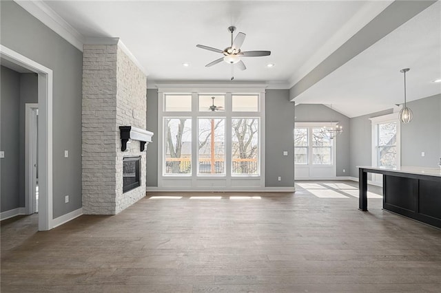 unfurnished living room featuring hardwood / wood-style flooring, ornamental molding, a fireplace, and ceiling fan with notable chandelier