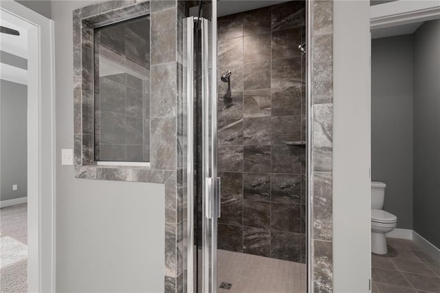 bathroom with toilet, tile patterned flooring, and a shower with door