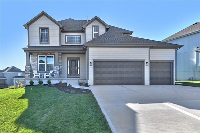 view of front of home featuring a porch, a garage, and a front lawn