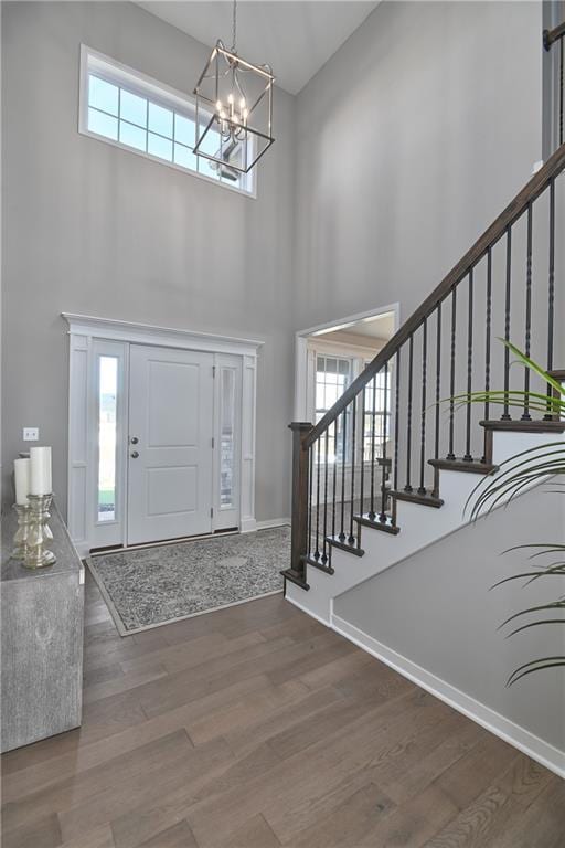 entryway featuring a high ceiling, hardwood / wood-style floors, and a chandelier