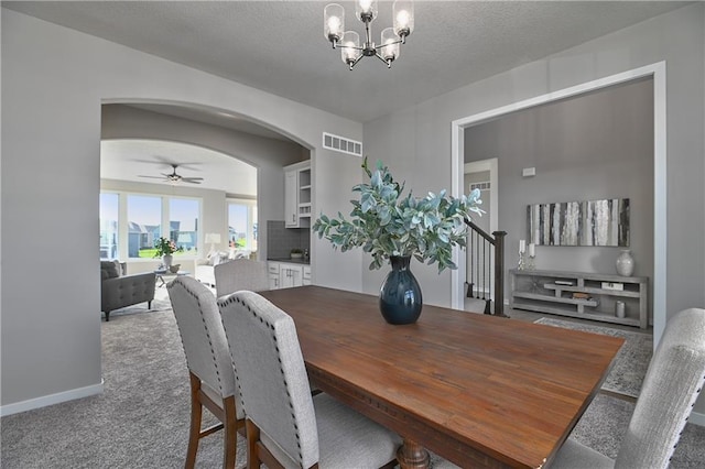 dining space with ceiling fan with notable chandelier and carpet floors