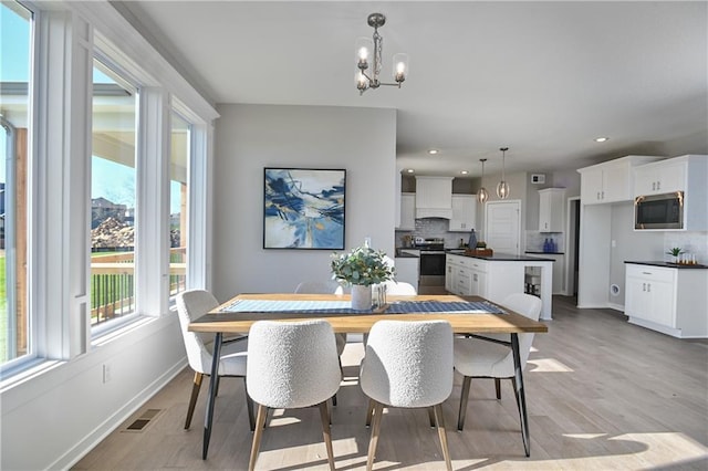 dining room with an inviting chandelier and light hardwood / wood-style flooring