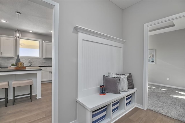 mudroom with sink and light hardwood / wood-style floors