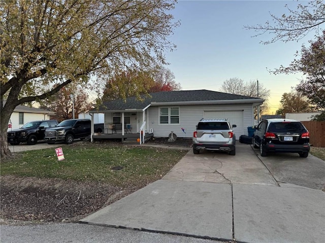 single story home with a garage, a porch, and a yard