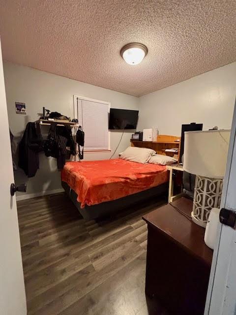 bedroom featuring dark wood-type flooring and a textured ceiling