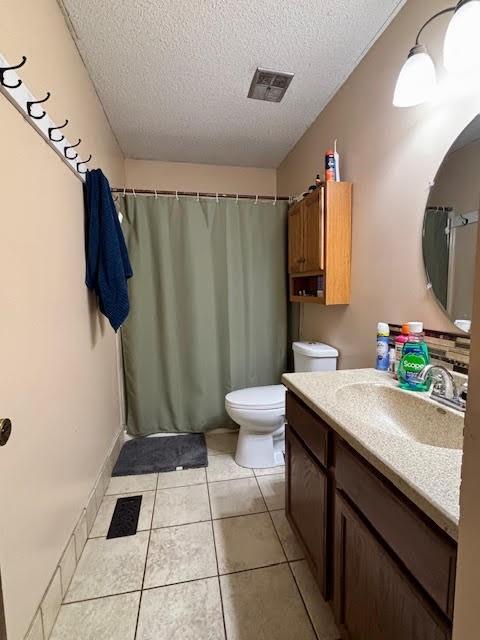 bathroom with vanity, tile patterned floors, a textured ceiling, and toilet