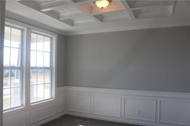 unfurnished room with beamed ceiling, dark colored carpet, and coffered ceiling