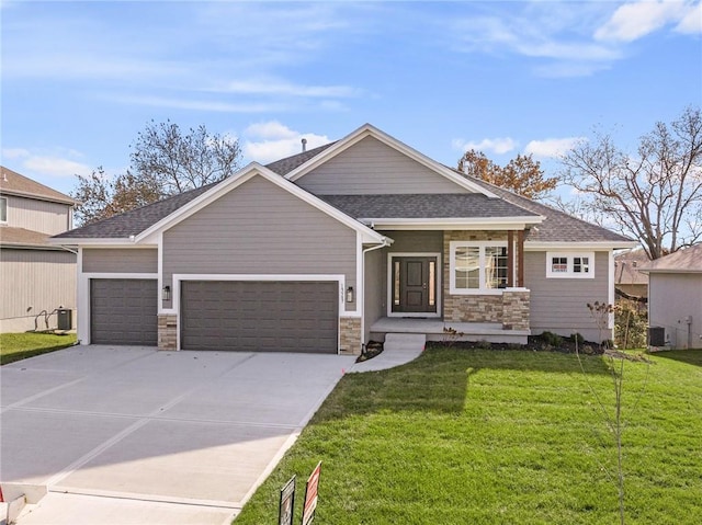 view of front of home featuring a garage, cooling unit, and a front lawn