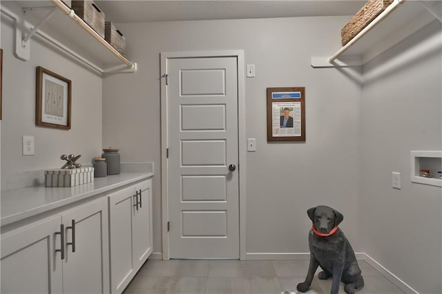 washroom featuring hookup for a washing machine and cabinets