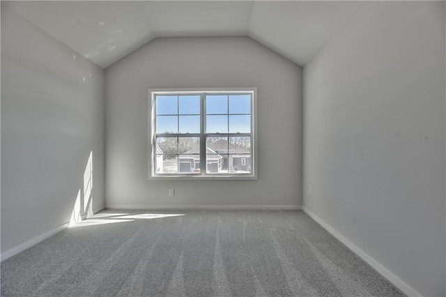 carpeted spare room featuring lofted ceiling