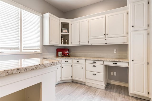 kitchen featuring white cabinetry and light stone countertops