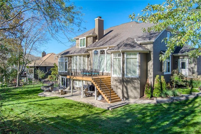 rear view of property with a patio area, a lawn, and a wooden deck