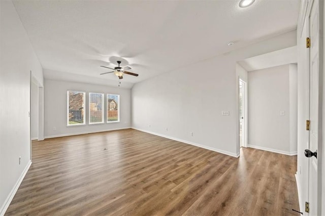 empty room with dark hardwood / wood-style floors and ceiling fan