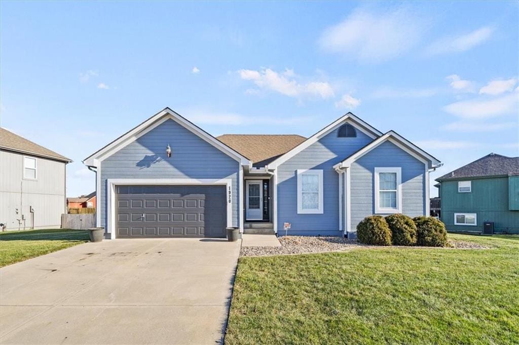 ranch-style home featuring a garage and a front lawn