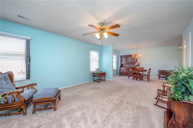 living area with a textured ceiling, plenty of natural light, visible vents, and baseboards