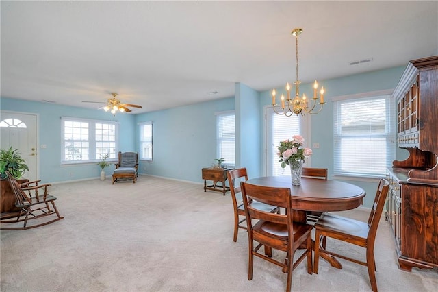 dining area featuring light carpet, visible vents, baseboards, and ceiling fan with notable chandelier